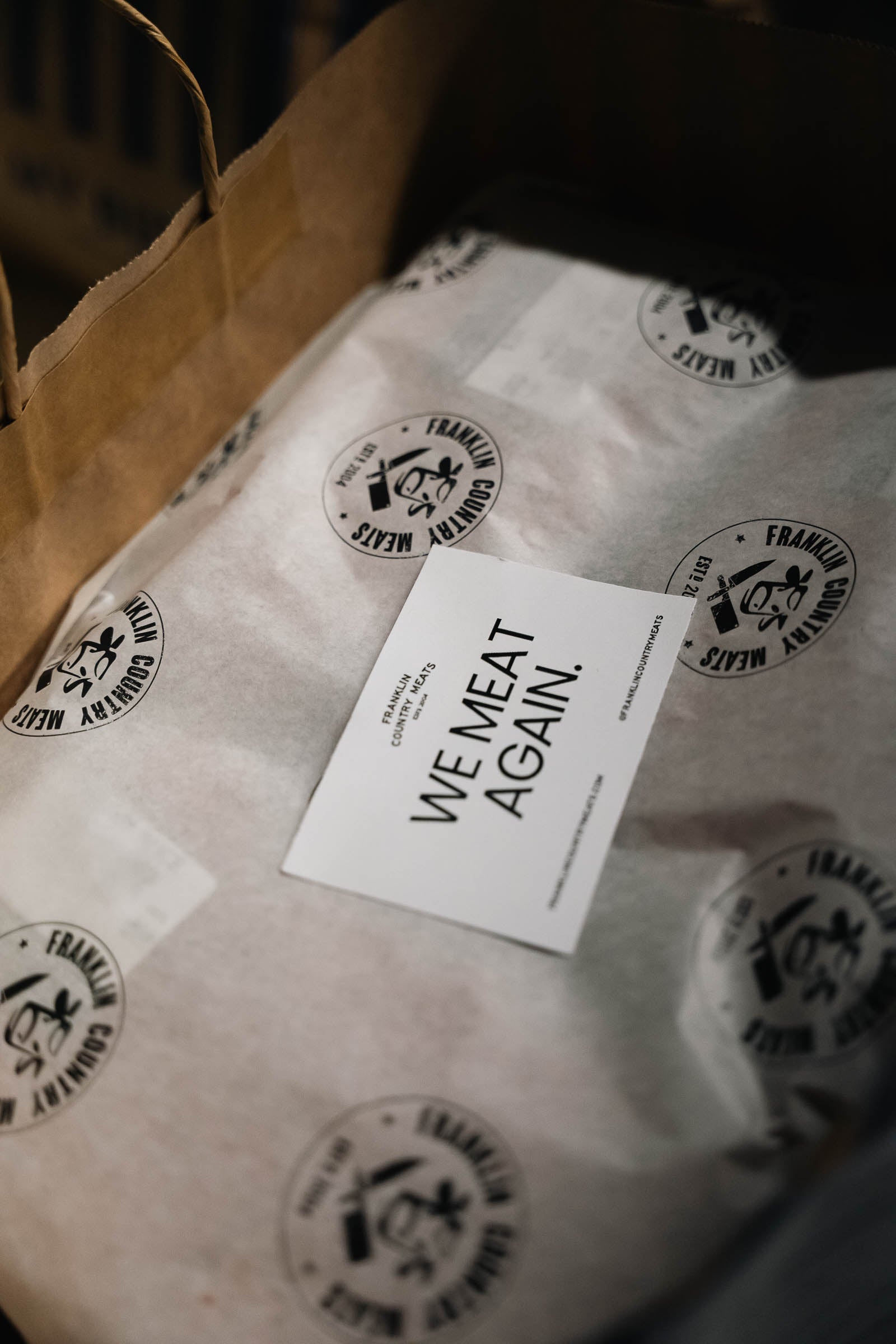 Packaged food with 'We Meat Again' label on branded paper