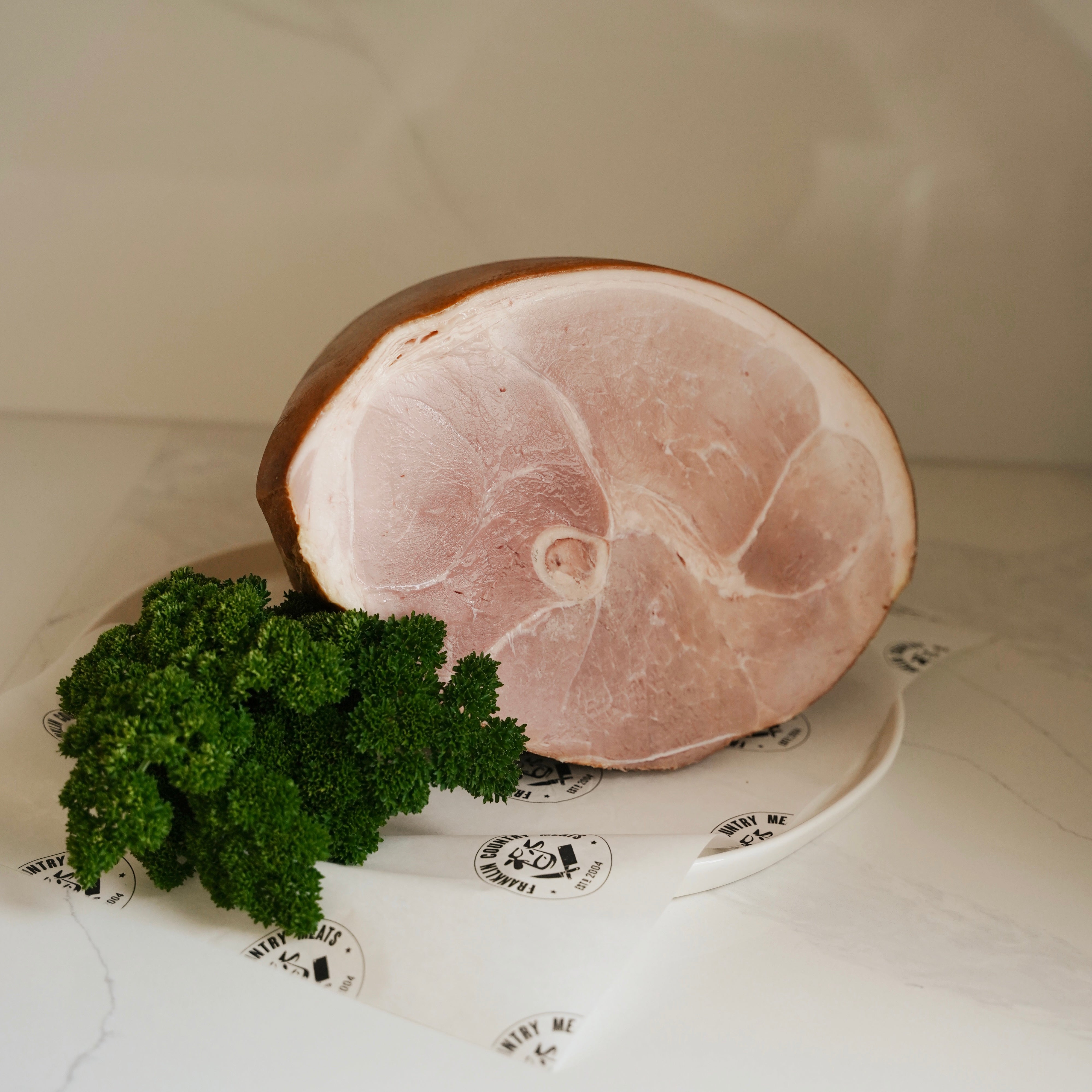 Ham and parsley on a white surface with a neutral background